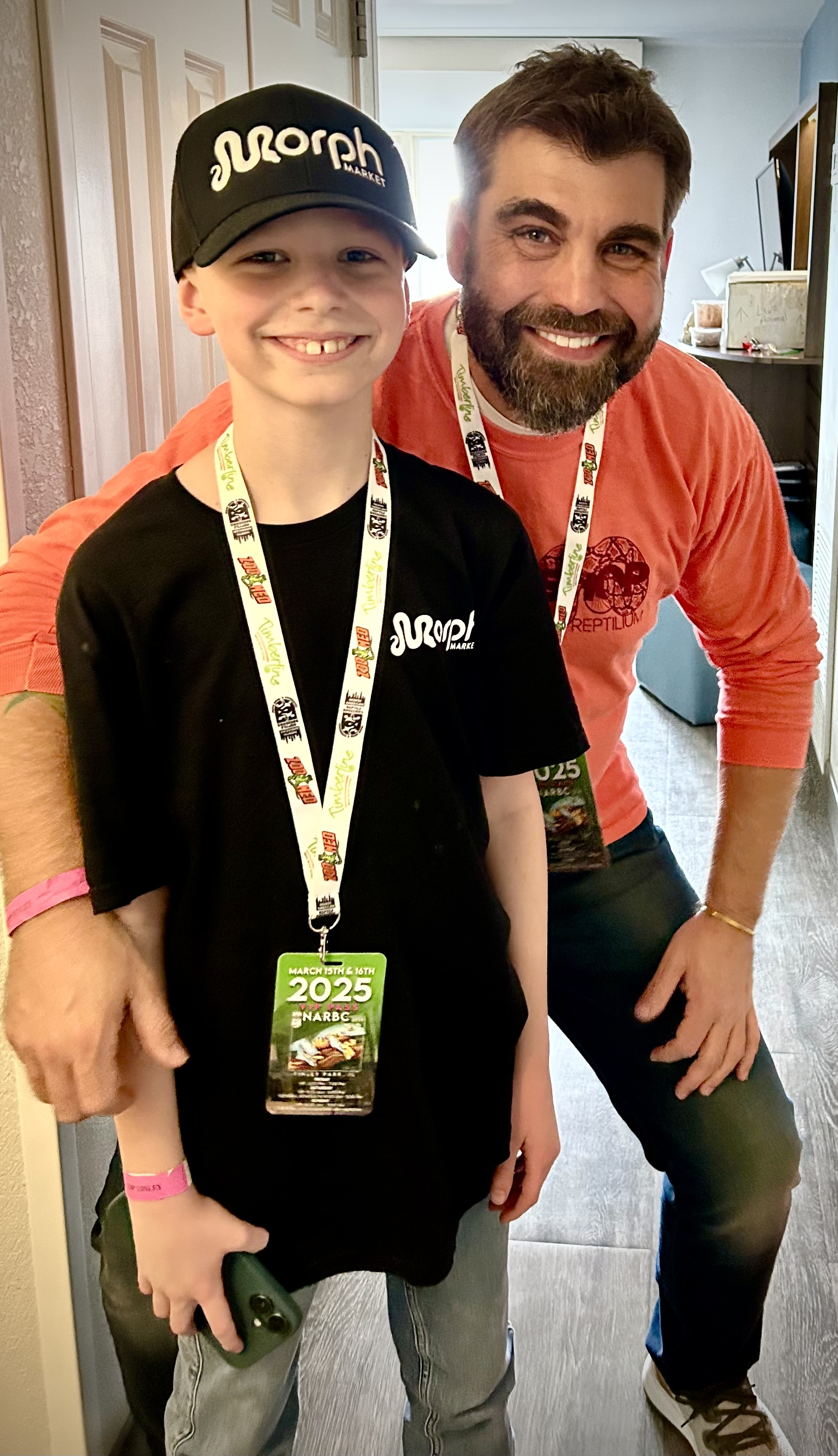 Two smiling reptile enthusiasts wearing NARBC event badges